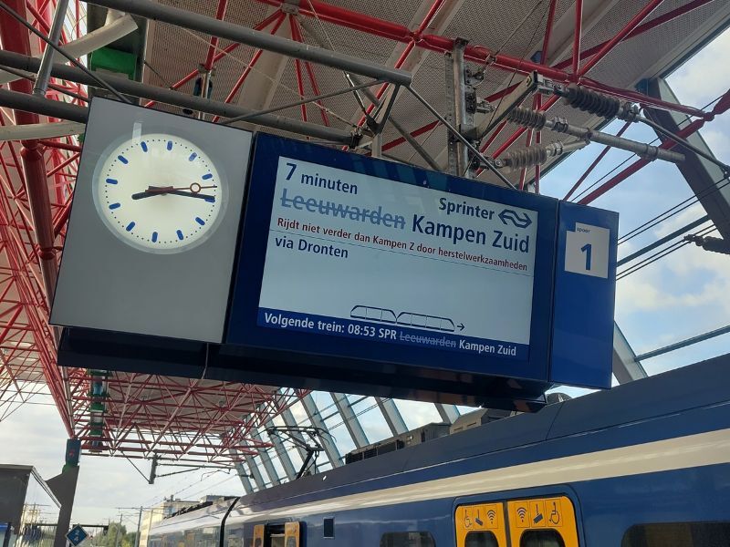Bord op treinstation waar treintijden opstaan