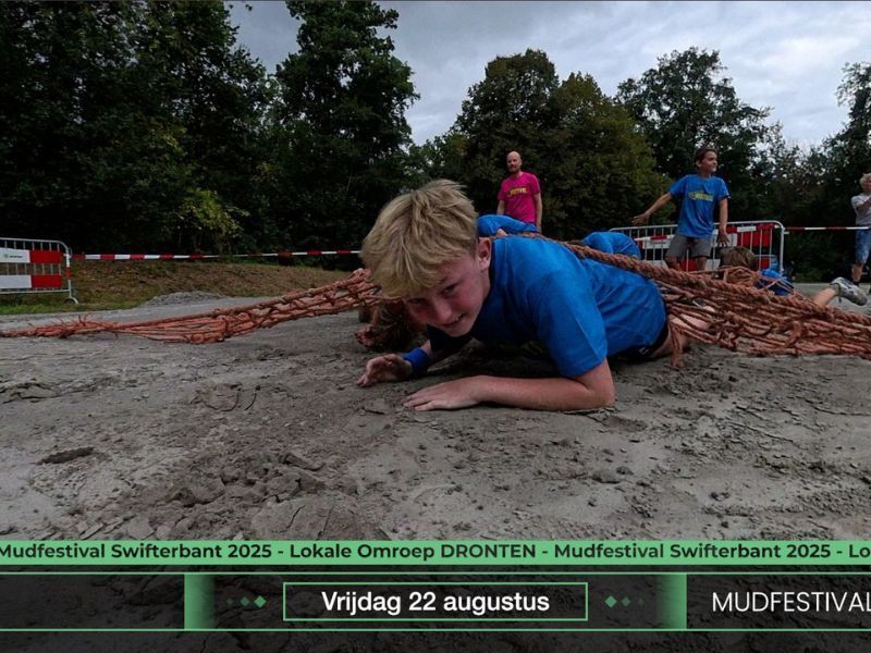 Deelnemers Mud festival Swifterbant kruipen door de modder
