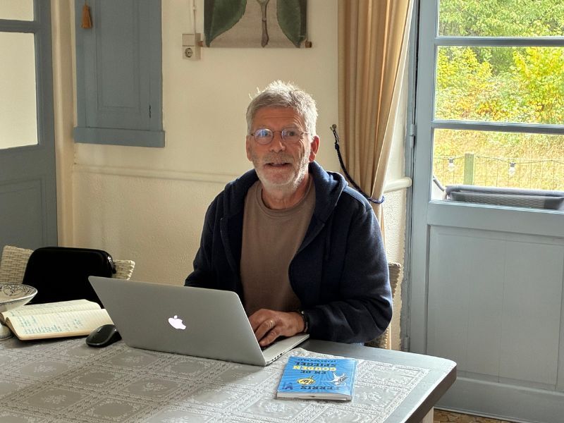 Frans van Baal, kinderboekenschrijver, achter zijn laptop