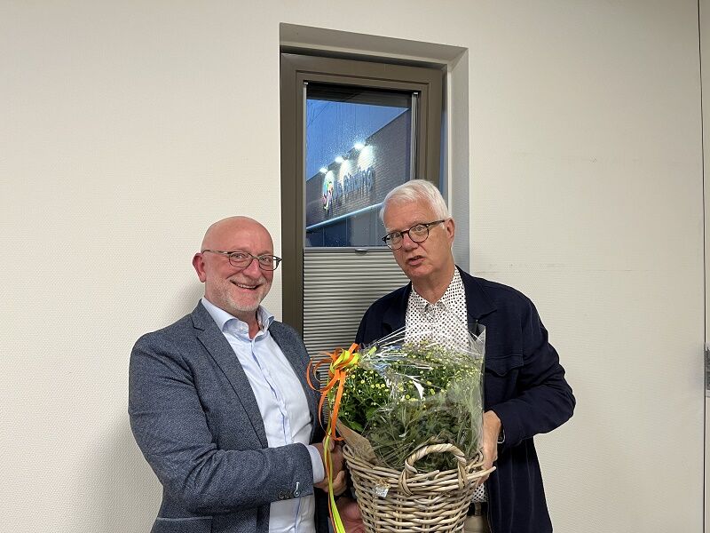 De nieuwe lijsttrekker Peter Bentum van Leefbaar Dronten krijgt bloemen van zijn voorganger Jan Ammerlaan.