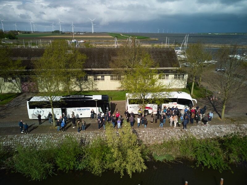 omgevingsfoto met bussen en groep mensen