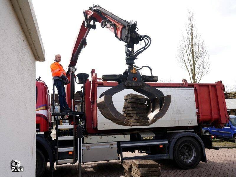 Grote vrachtwagen takelt tegels omhoog.